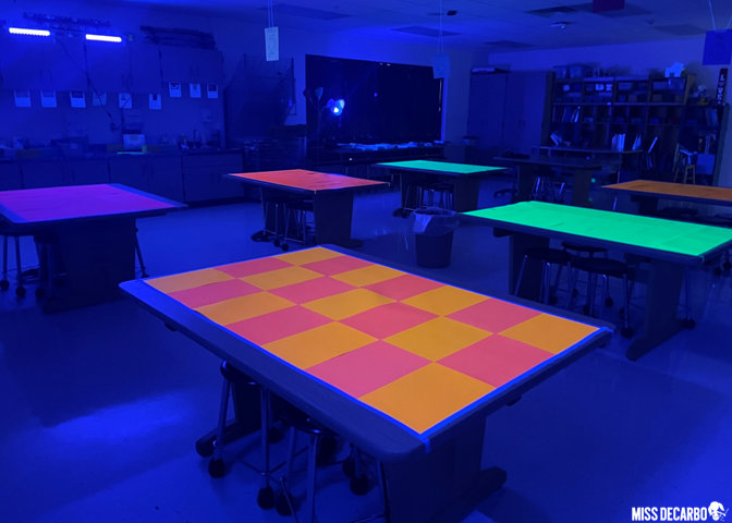 Cover tables with glow-in-the-dark cardstock to create a glow-themed read aloud room for literacy night!